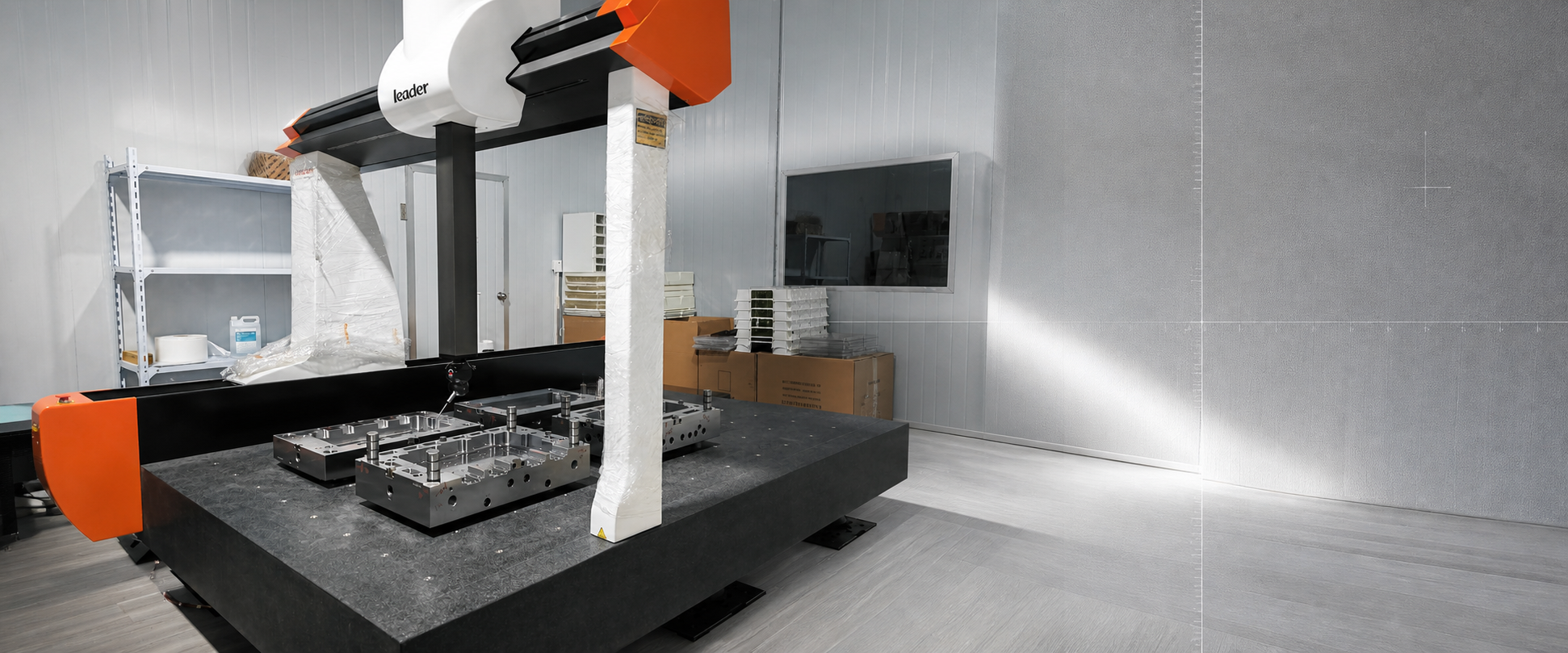 Coordinate measuring machine inspecting a mold base component in a dedicated measurement room